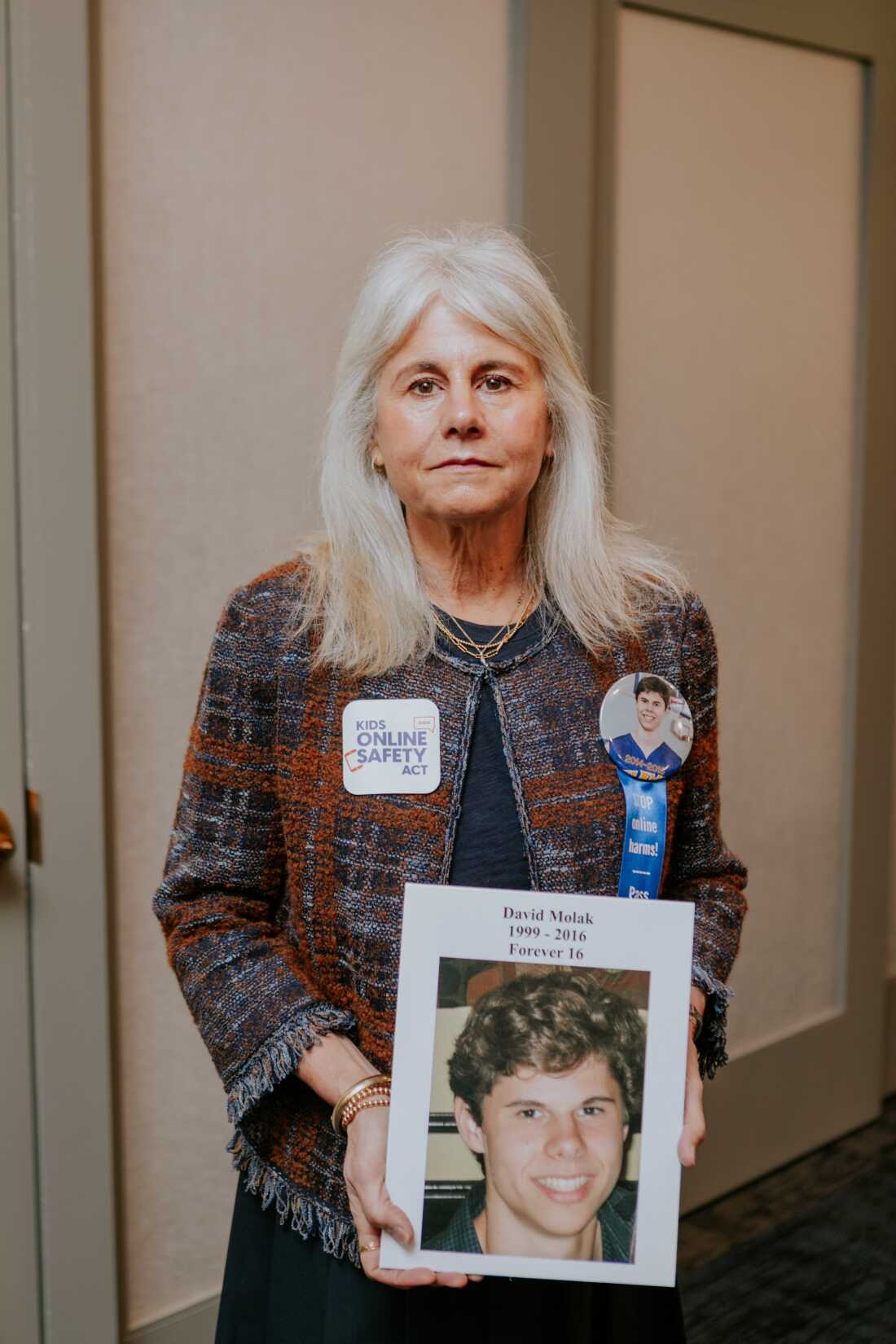 Maurine Molak holds a photo of her 16-year-old son, David, who died by suicide after months of relentless online threats and cyberbullying.