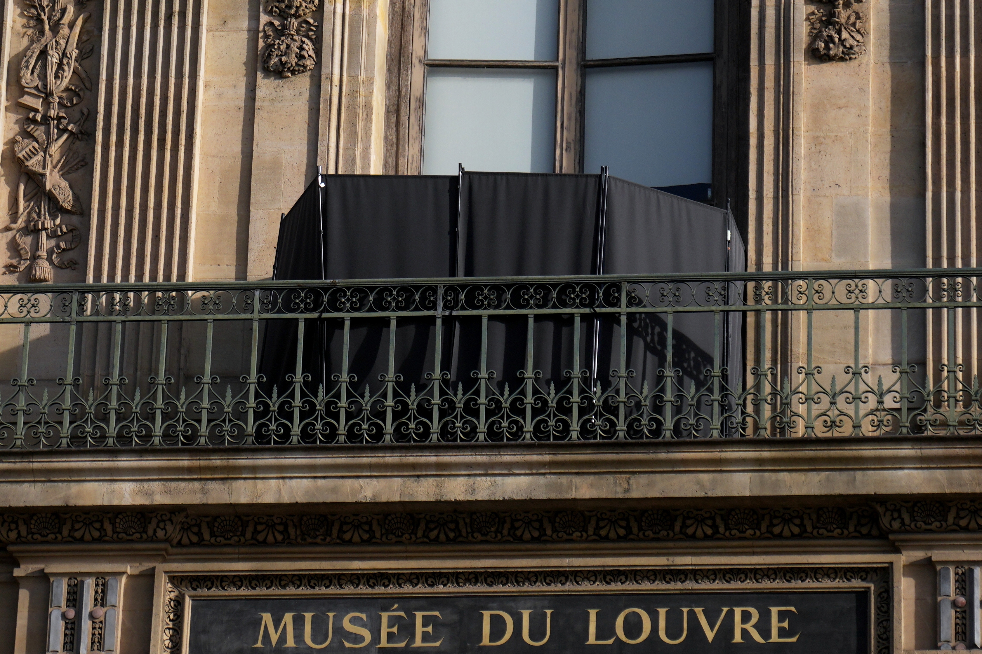 A black curtain hides the window where thieves entered the Louvre museum in Paris, pictured on Oct. 22, three days after historic jewels were stolen in a daring daylight heist.