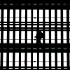 In this file photo, a man using a smartphone passes through the arched windows at Grand Central Terminal in New York City on March 24, 2025.