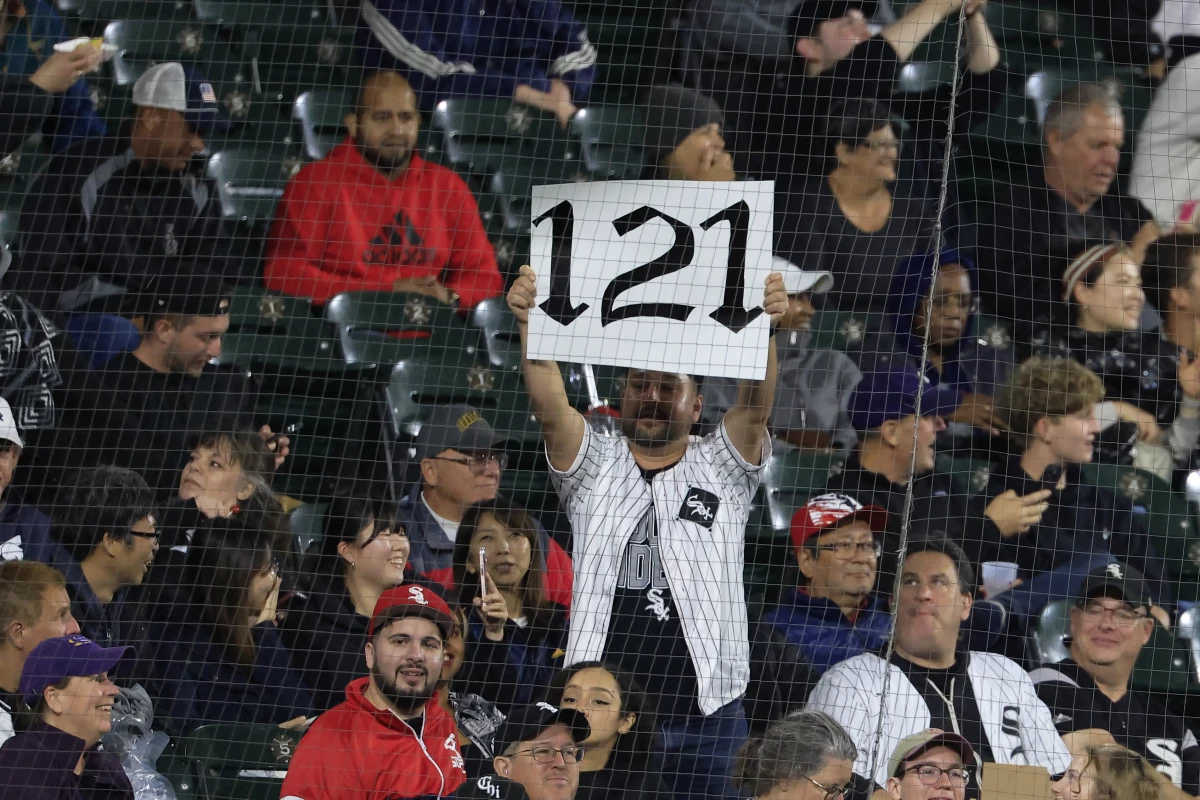 A fan holds up a '121' sign during a game this week in Chicago. The White Sox must now win three more games — and set their longest winning streak of the season — to avoid hitting 121 losses.