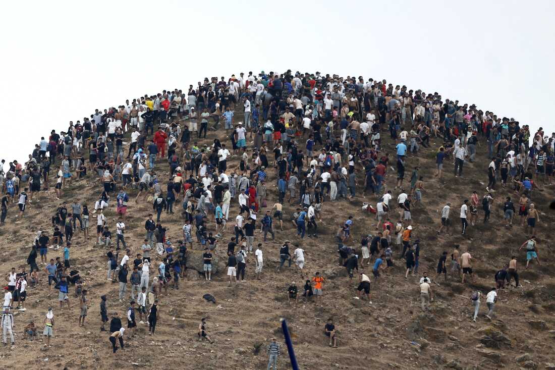 People gather on a hilltop close to the site of clashes near Fnideq, on the Morocco-Spain border on Friday.