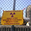 A sign warning of radioactive materials is attached to a fence outside a nuclear power plant. 