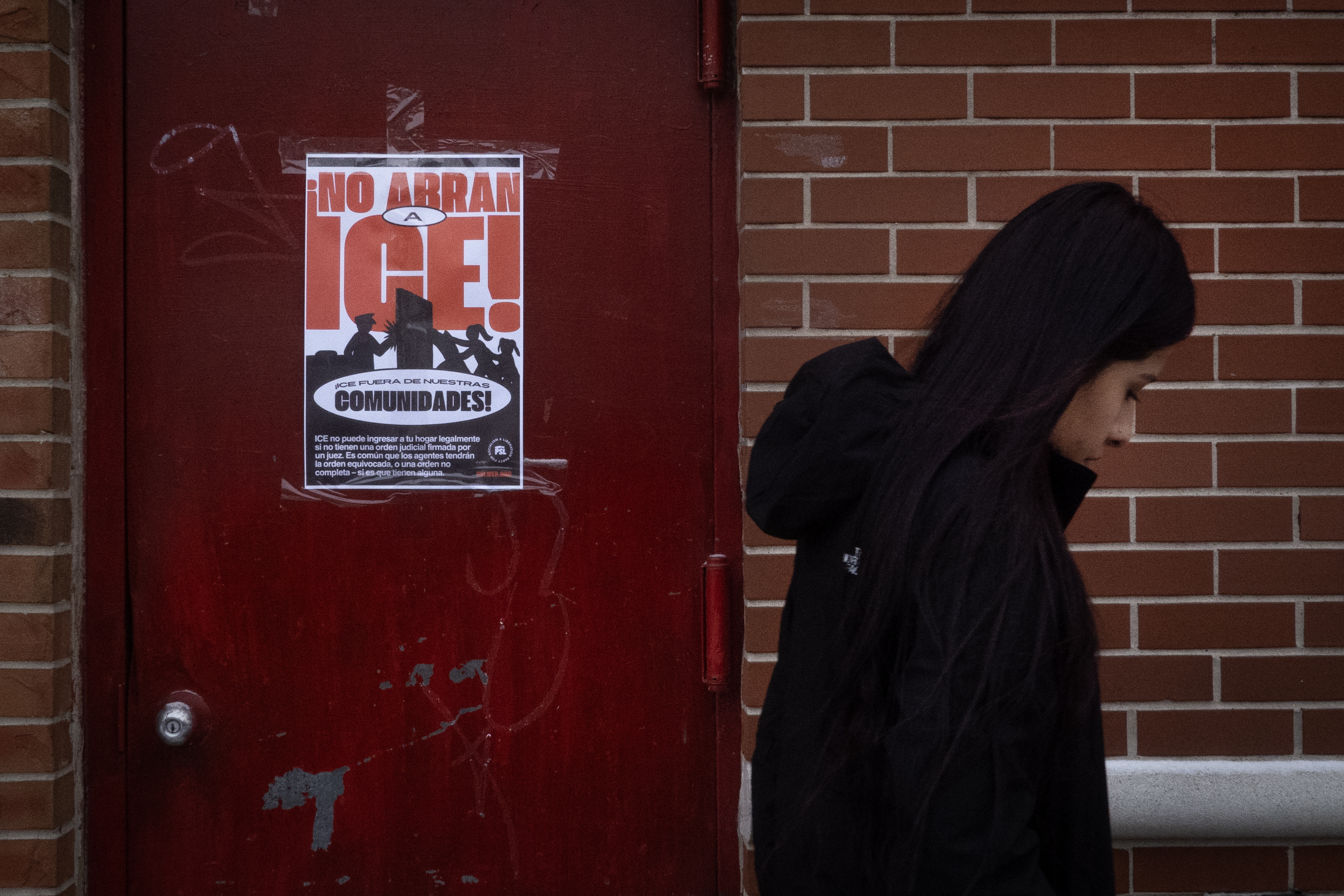 A poster calling on U.S. Immigration and Customs Enforcement (ICE) to get out of the community hangs on a door in the Little Village neighborhood on January 22, 2025 in Chicago, Illinois.