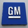 This photo shows General Motors' logo. It's a blue square with "GM" in white capital letters in the middle, with a white horizontal bar underneath the letters.