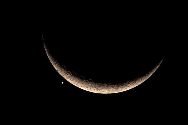 The crescent moon and Venus are pictured in Bangkok in 2023. A failed Soviet lander bound for Venus in 1972 and stranded in orbit is finally set to return to Earth.