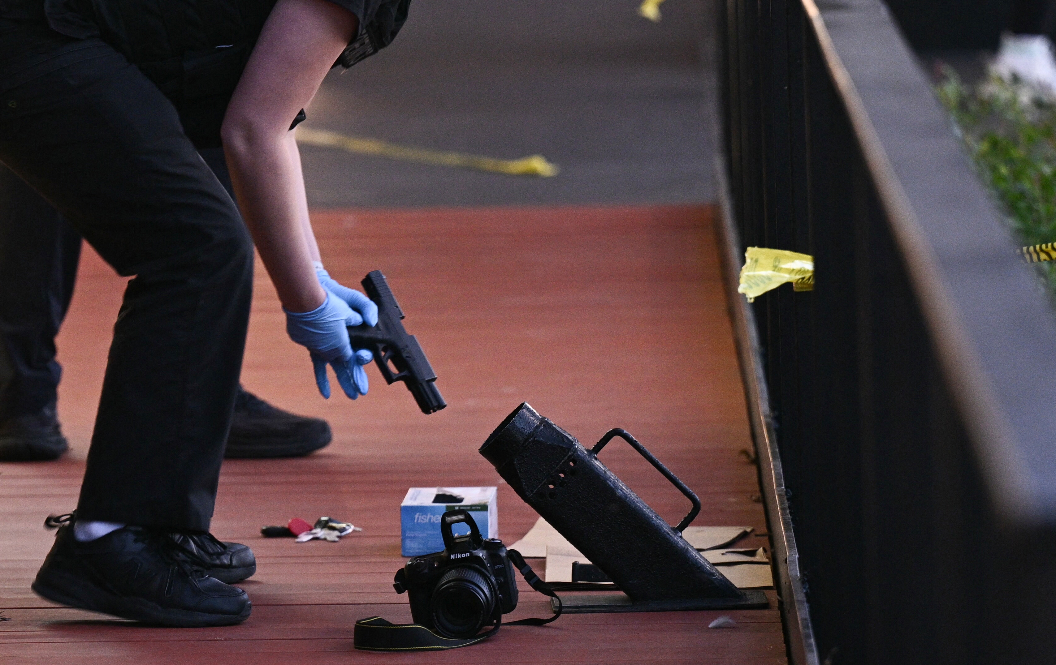 A law enforcement officer inspects a handgun at the scene of a shooting in Washington, D.C., on Oct. 2.