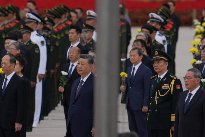Chinese President Xi Jinping, center left and Zhang Shengmin, Vice Chairman of the Central Military Commission second from right attend a ceremony in honor of fallen national heroes at the Monument to the People