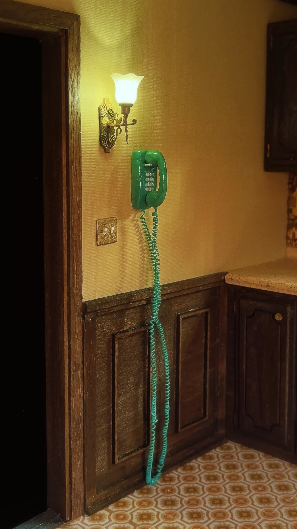 A tiny blue phone is shown in a vintage kitchen created by artist Marina Totino.