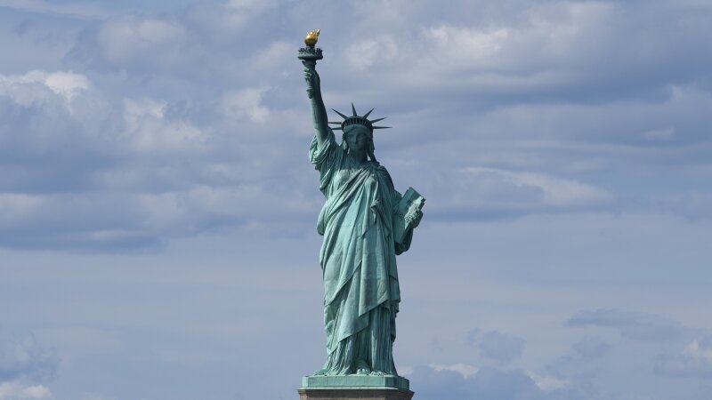 The Statue of Liberty pictured against a blue sky.
