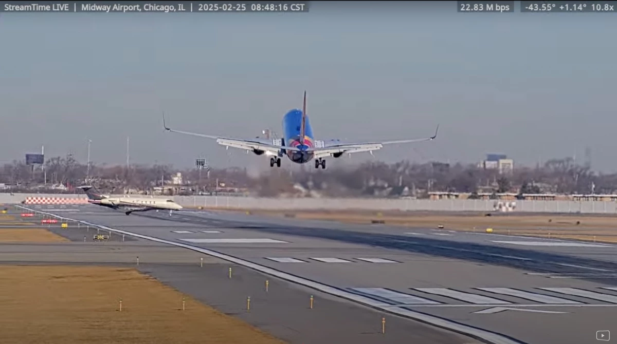 A screenshot from the StreamTime Live account on Youtube of the near-collision between a Southwest 737 plane and a private business jet at Chicago's Midway Airport. The 737 flight was arriving from Omaha when the business jet mistakenly crossed the runway.