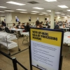 People extract ballots from their envelopes and prepare them to be scanned for counting in the Vote-By-Mail Processing Boards area at the Orange County Registrar of Voters Facility in Santa Ana, Calif., on Oct. 28.