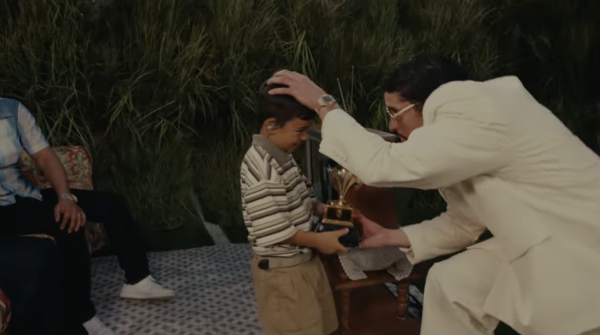 A screenshot of Bad Bunny giving a Grammy to a young boy during the Super Bowl performance.