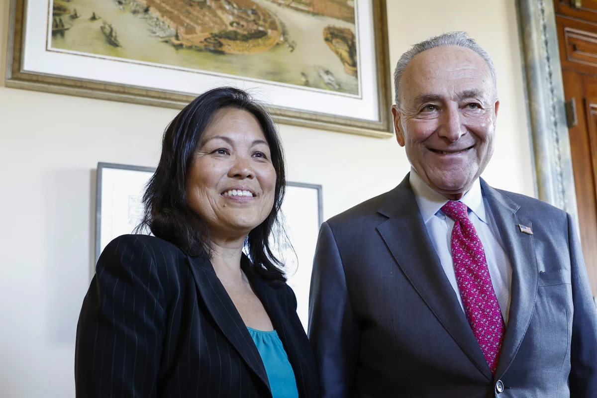 Senate Majority Leader Chuck Schumer poses for a photo with Julie Su at the U.S. Capitol on March 28, 2023, shortly after she assumed the role of Acting Labor Secretary.