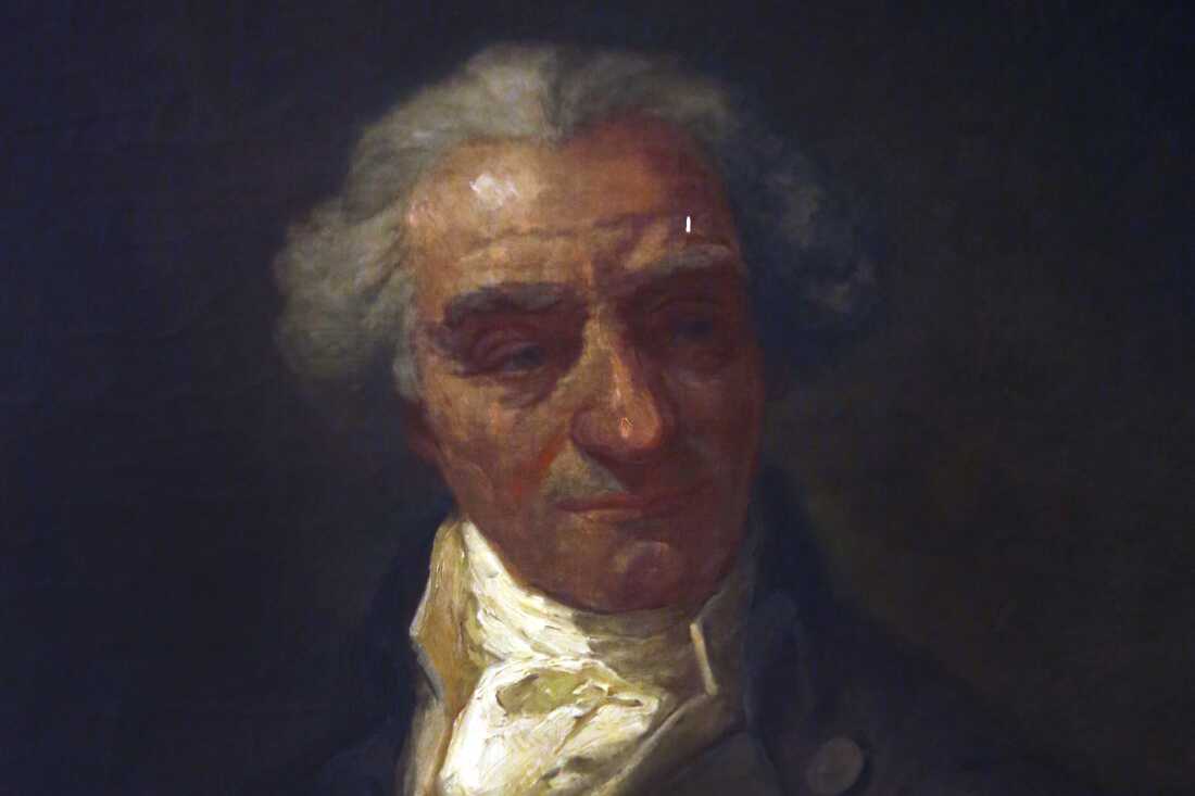 This photo shows a historical painting of Governor Elbridge Gerry. He has gray hair and is wearing clothing from the time of the American Revolution.