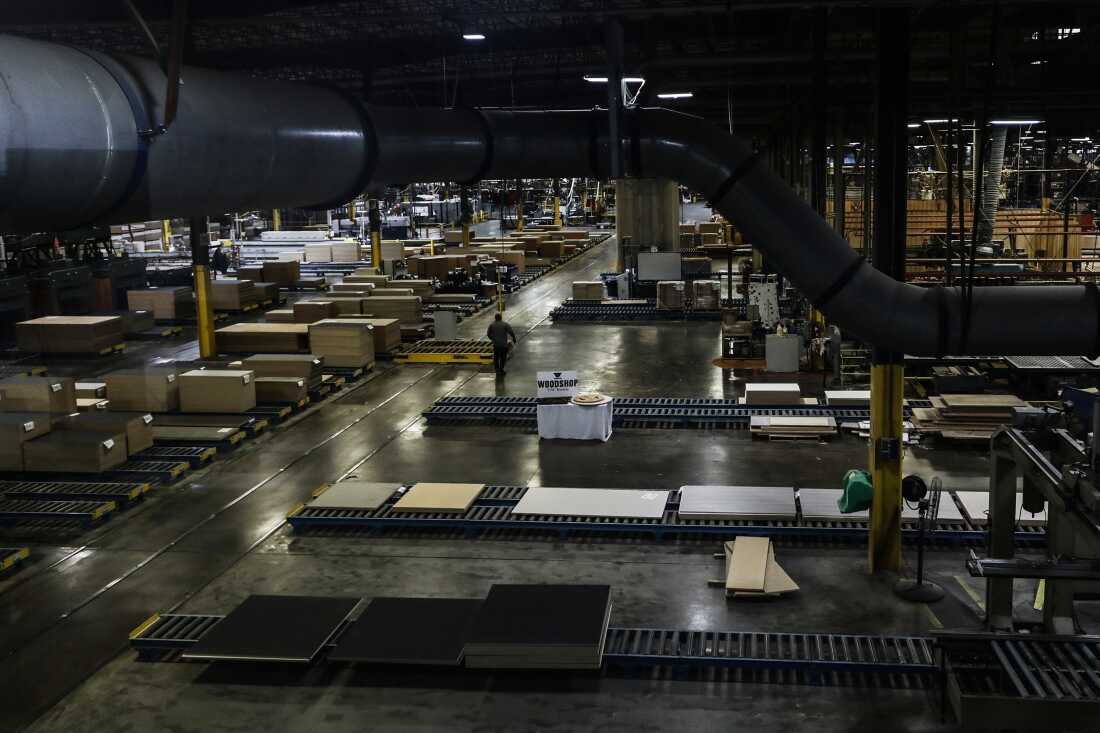 An employee walks by many cardboard boxes on the expansive factory floor at Virco.