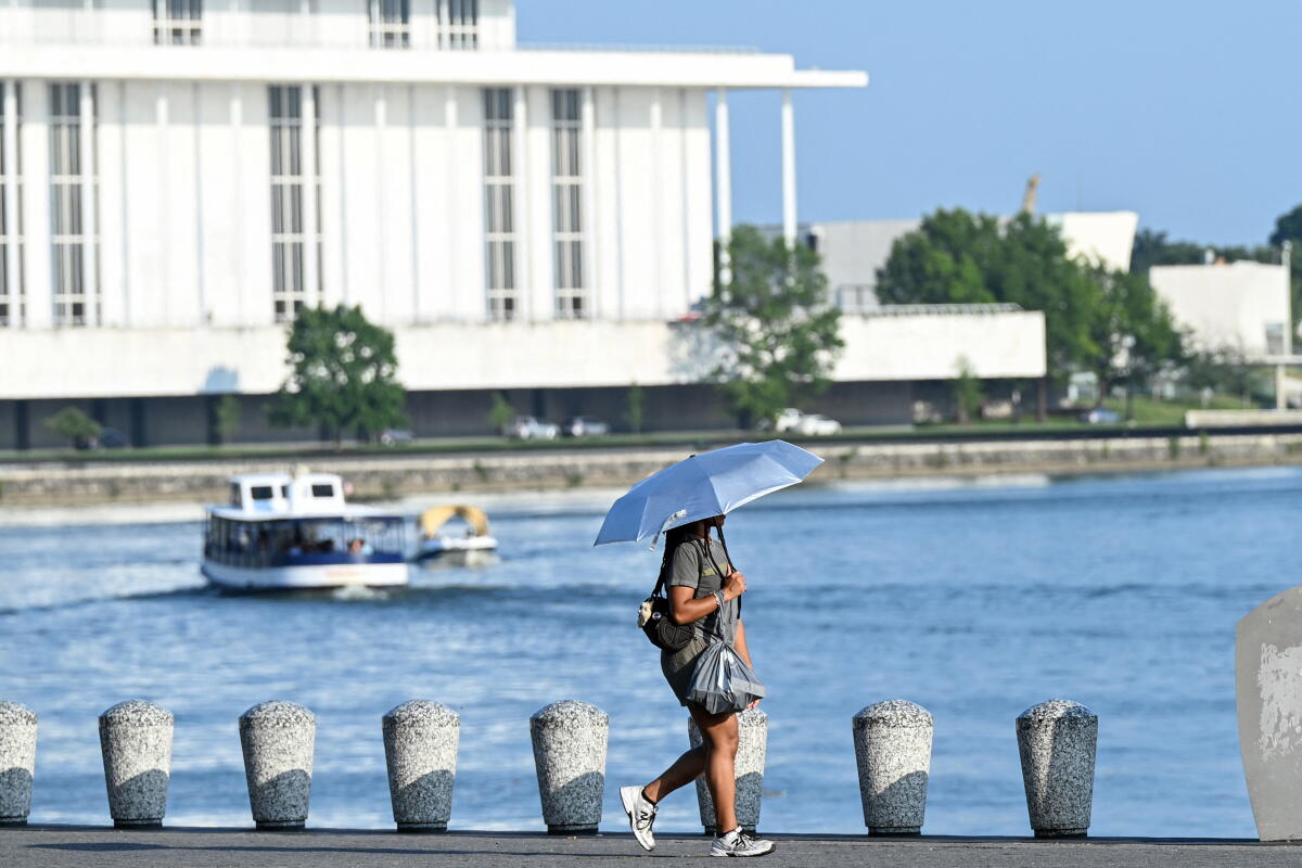 Did climate change cause this heat wave? Most likely, and here's why 1 A person uses an umbrella to stay cool while walking along the Potomac River during a heatwave in Washington, DC, in July.