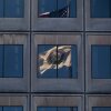 The reflection of the flag of the U.S. Department of Energy is seen on the department's headquarters building in Washington, D.C., in March. The Joint Office of Energy and Transportation, a unique government body designed to bring together expertise from the Department of Energy and the Department of Transportation, has been affected deeply by government-wide