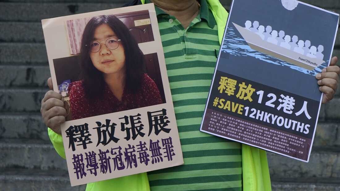 A pro-democracy activist holds placards with the picture of Chinese citizen journalist Zhang Zhan outside the Chinese central government's liaison office in Hong Kong on Dec. 28, 2020.