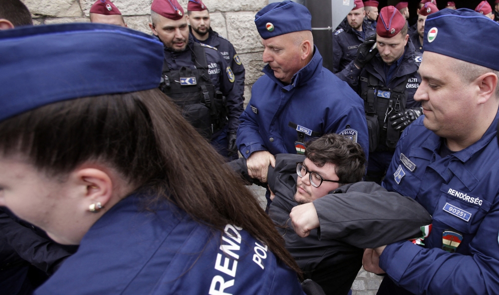 Hungarian police remove a protester blocking the entrance of the Parliament building in Budapest on April 14, as Hungarian lawmakers were expected to approve constitutional changes further clamping down on rights for certain groups, part of Prime Minister Viktor Orbán's "Easter cleanup" against his domestic opponents. (AFP via Getty Images)