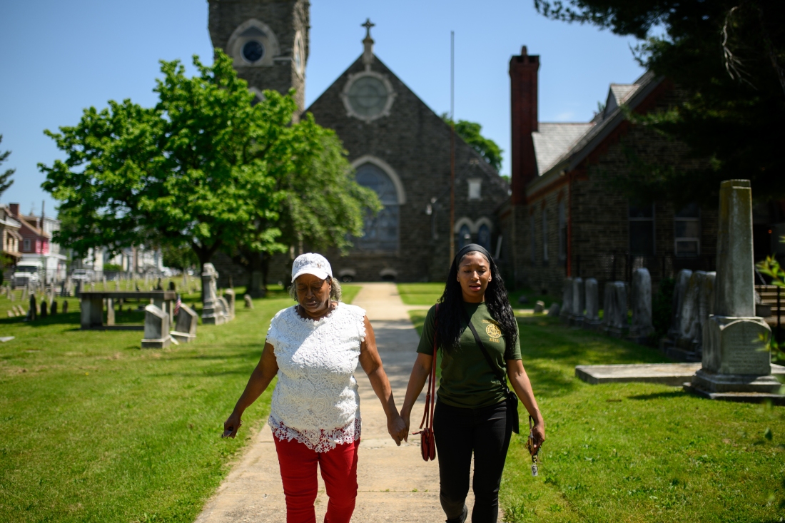 Karen Williams (left) holds hands with her daughter, Lena Powell, while walking through St. Michael's Lutheran Churchyard in Philadelphia. 