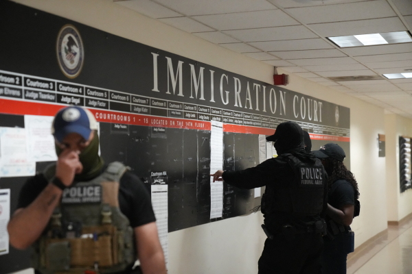 U.S. Immigration and Customs Enforcement agents look over lists of names and their hearing times and locations inside the Federal Plaza courthouse before making arrests in June 2025 in New York.