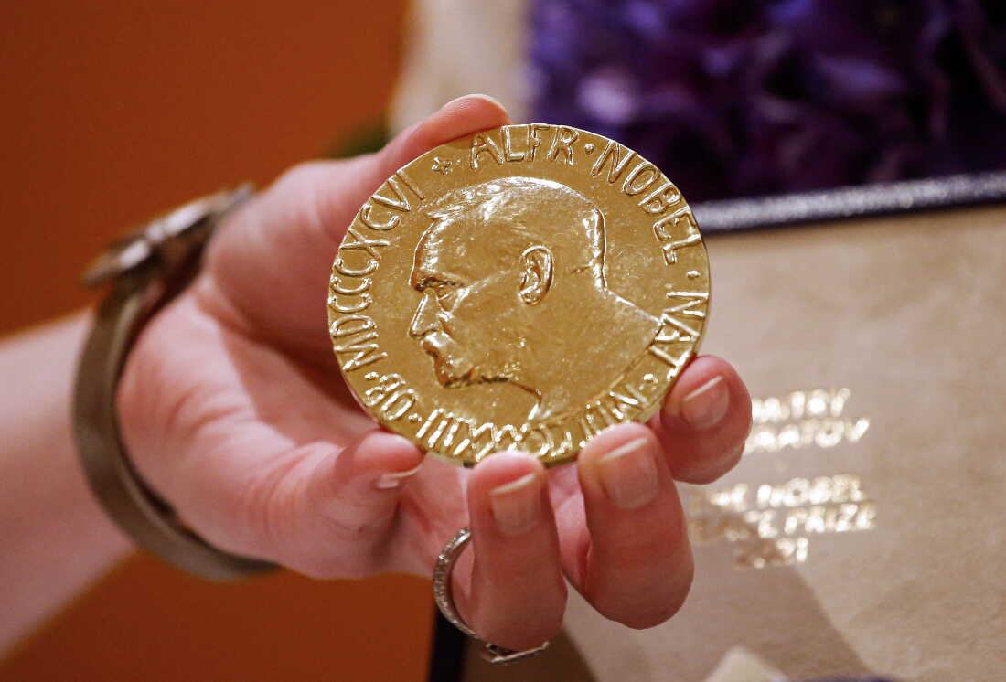 A woman holds Russian journalist Dmitry Muratov's 2021 Nobel Peace Prize medal in New York in 2022.