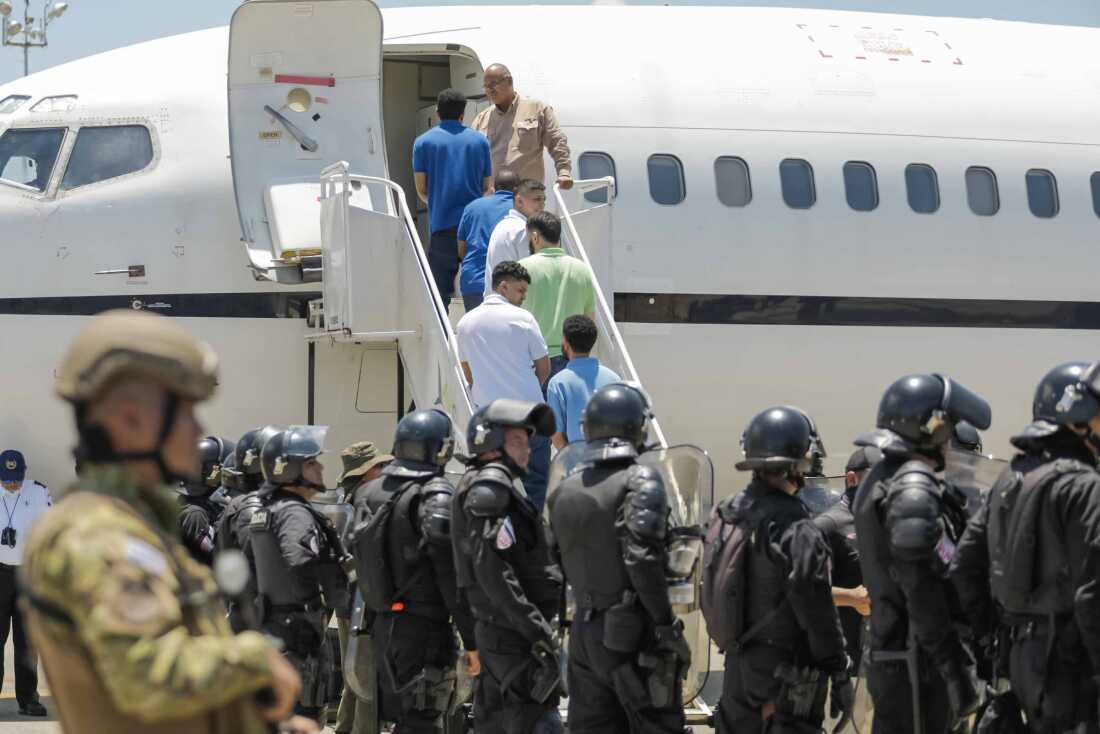 Venezuelan migrants accused by the U.S. of belonging to the Tren de Aragua criminal gang are seen being transferred from the Terrorism Confinement Center (Cecot) in El Salvador before being repatriated to Caracas on July 18, 2025 in La Paz, El Salvador.