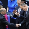 Leader of the Christian Democratic Union of Germany, Friedrich Merz, is congratulated by outgoing Chancellor Olaf Scholz after being elected new chancellor at the German federal parliament, Bundestag, at the Reichstag building in Berlin, Tuesday.