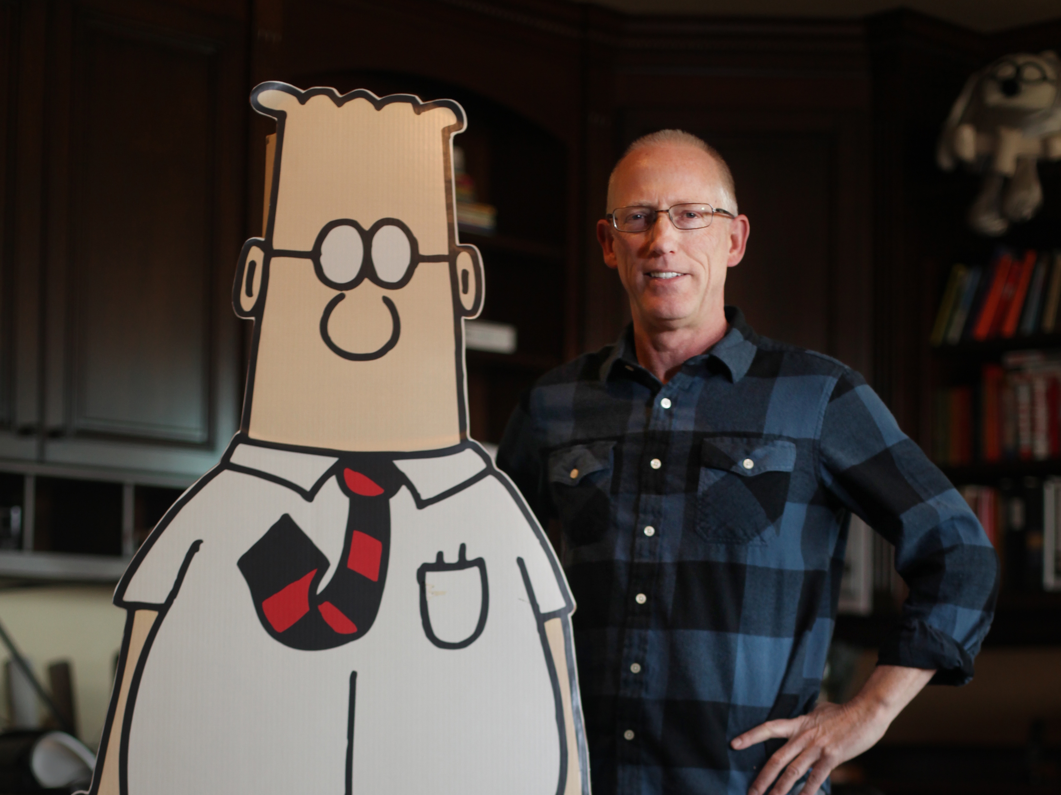 Cartoonist Scott Adams poses with his a life-size cutout of his creation, Dilbert, in 2014.