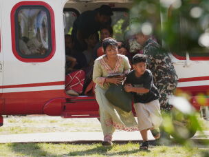 Army soldiers help a family disembark from a helicopter after they are rescued from an area affected by flash flooding in Nepal's Nuwakot district, Friday, Aug. 28, 2026.