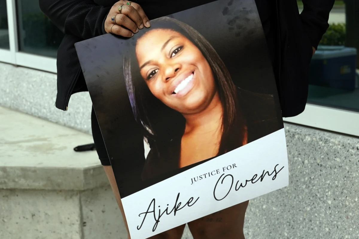 A protester holds a poster of Ajike Owens and demands the arrest of a woman who killed her during a rally at the Marion County Courthouse, June 6, 2023, in Ocala, Fla.