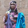 Mariam Mohammed, a widow, stands outside her home in Bama, Nigeria. She's holding her younger son Babagana's favorite clothes.