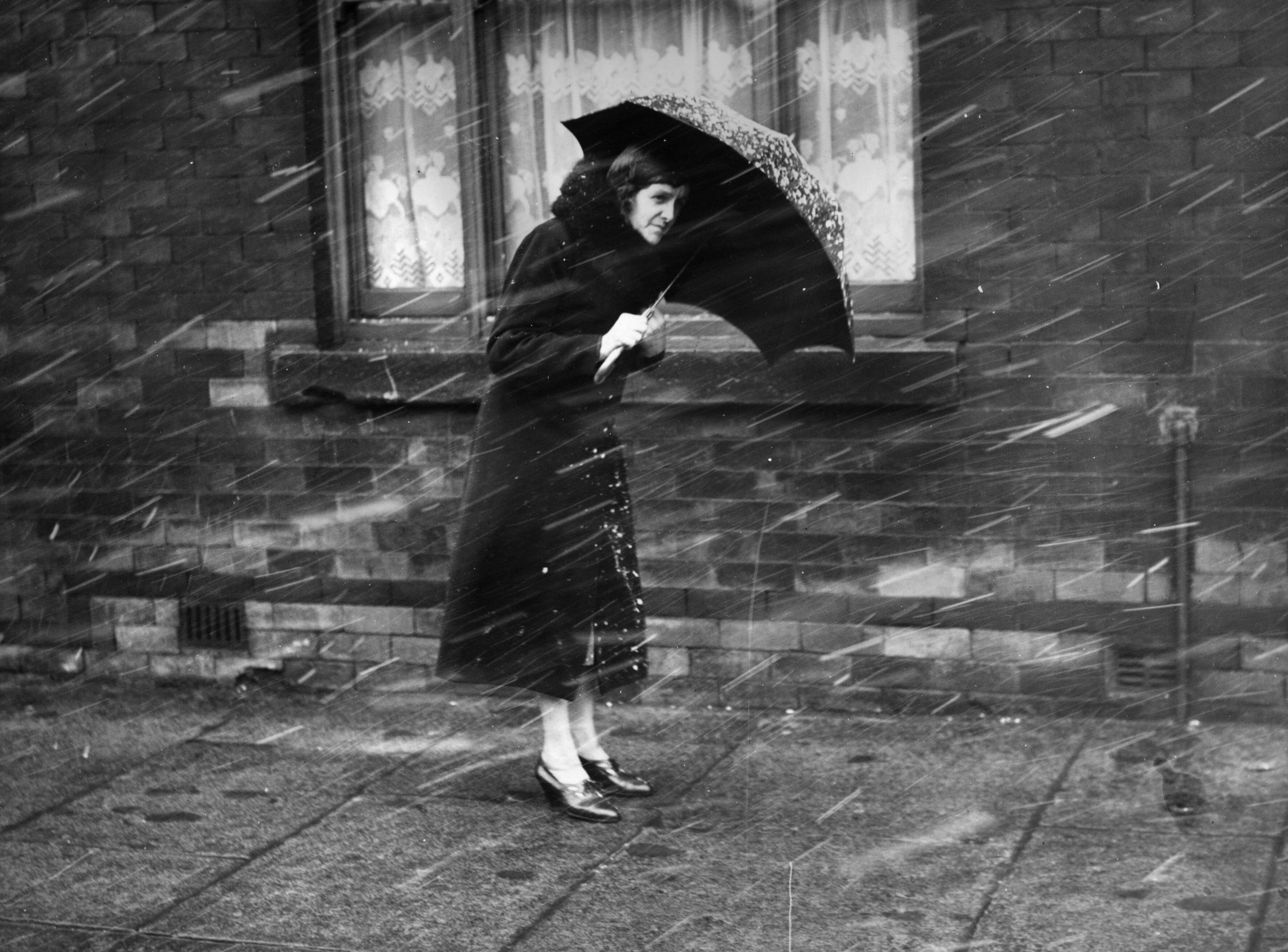 A woman walks through a snowy street in Manchester in 1939.