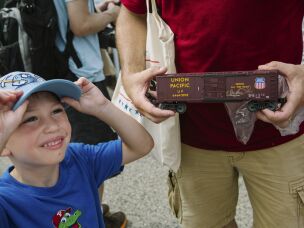 Joe Stefankiewicz, 37, of Aston, Pennsylvania, holds a signed model train car for his son, Joey, 5, in front of Union Pacific's Big Boy No. 4014, the world's largest operating steam engine locomotive, during a stop in Philadelphia.