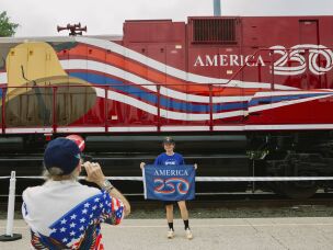 Adam Lapham, 25, of Green, Ohio, stands for a photograph taken by his grandfather, James Wallace, 74, in front of a train car connected to Union Pacific's Big Boy No. 4014, the world's largest operating steam engine locomotive, during a stop in Philadelphia.