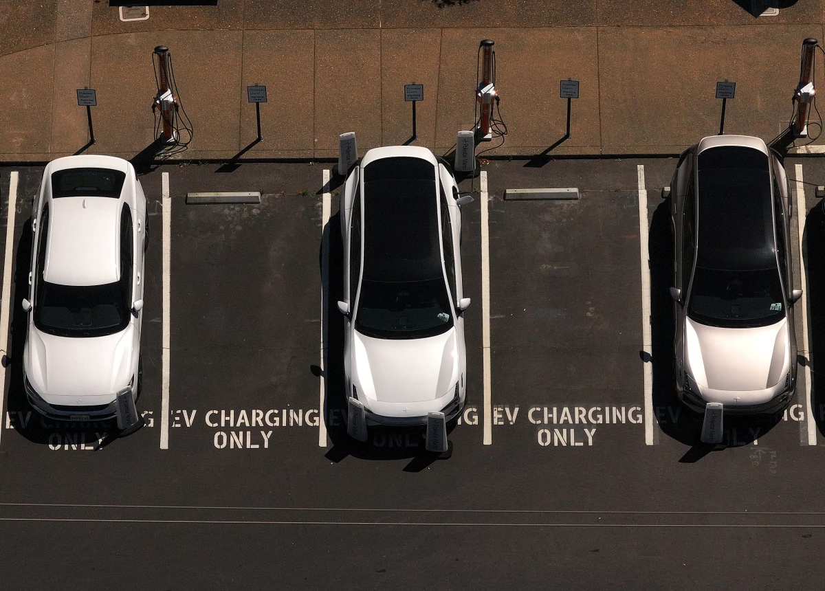 Electric cars sit parked at a charging station in Corte Madera, Calif., in May 2025.