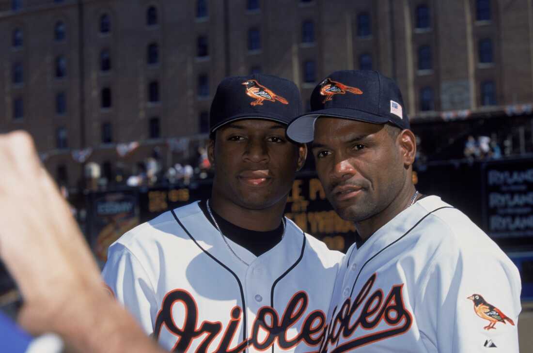 Baltimore Orioles left fielder Tim Raines Sr. #30 poses with his son, Baltimore Orioles center fielder Tim Raines Jr. #63 before an October 2001 game.