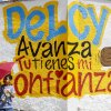 A boy holding an umbrella stands in front of a mural in support of Venezuela's interim president Delcy Rodriguez that reads "Delcy, move forward, you have my trust" in Caracas on February 2, 2026.