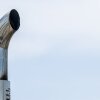 This photo is a close-up of a shiny metal exhaust pipe atop a truck in Austin, Texas.