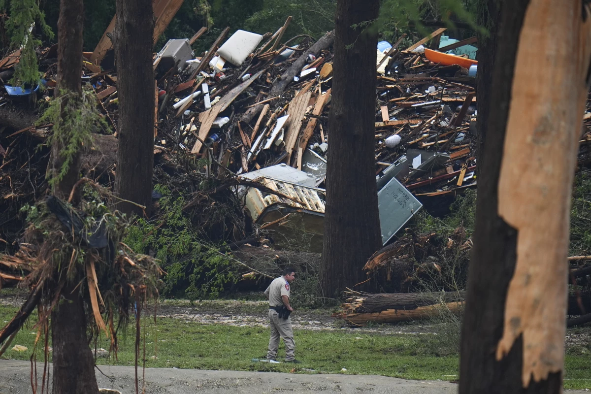 Officials comb through the banks of the Guadalupe River after a flash flood swept through the area in Hunt, Texas.