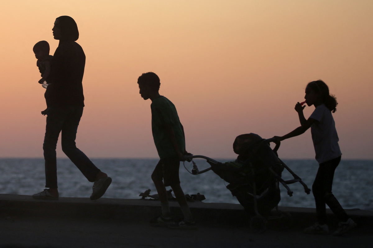 Displaced Palestinians carry their belongings along a road in the Nuseirat refugee camp area in central Gaza on Sept. 20 of this year, as Israel advanced its ground offensive toward Gaza City.
