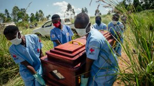 Members of a Congolese Red Cross team carry the coffin of a woman suspected of having died from Ebola virus disease during her safe burial at a cemetery in Bunia on June 7, 2026.