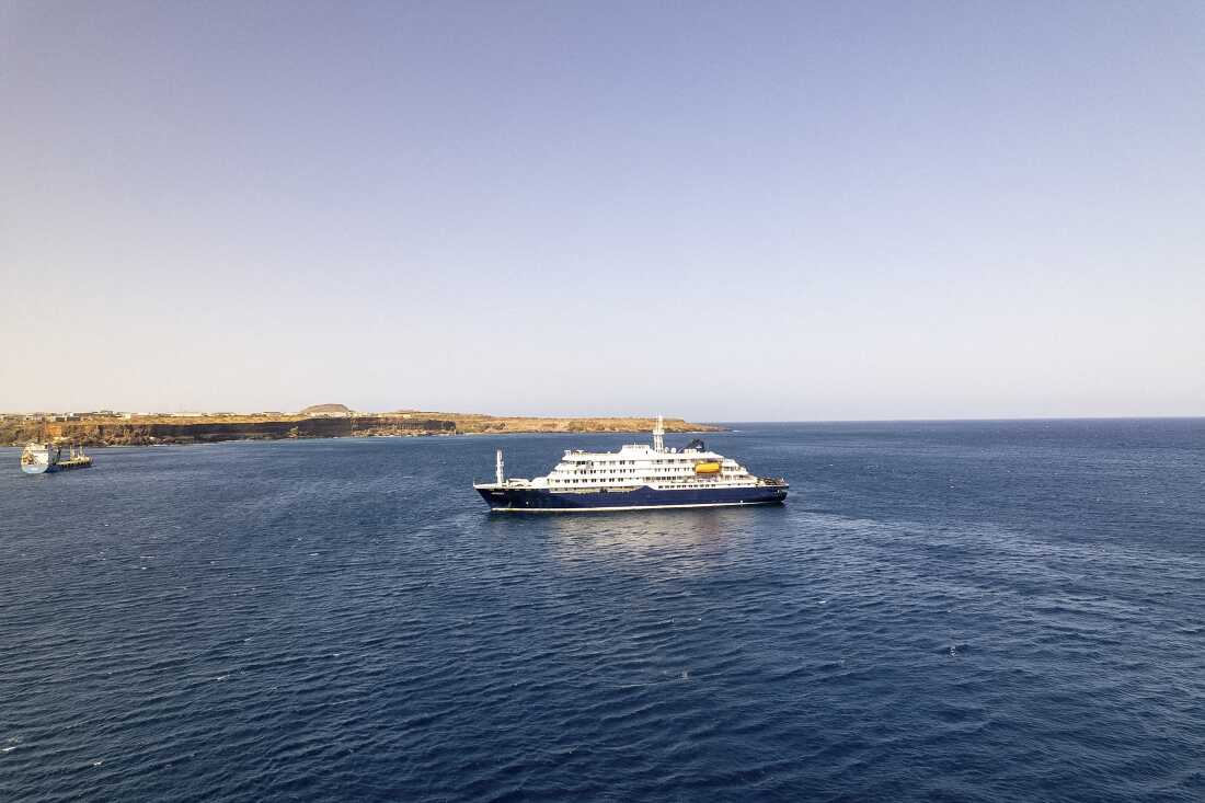 This aerial picture shows a general view of a cruise ship off the port of Praia, the capital of Cape Verde, on Sunday. Three people have died in an outbreak of a dangerous respiratory virus on a cruise ship in the Atlantic Ocean, according to the World Health Organization.