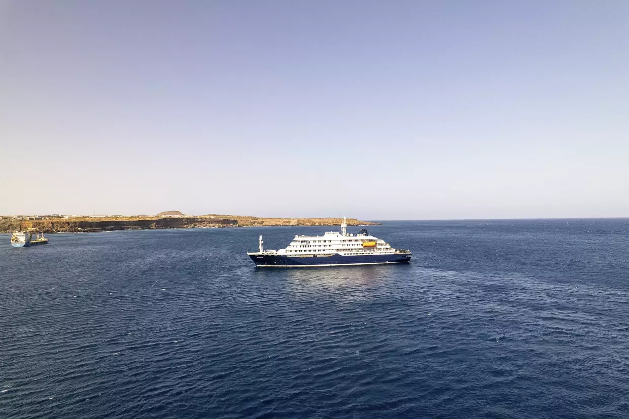 This aerial picture shows a general view of a cruise ship off the port of Praia, the capital of Cape Verde, on Sunday. Three people have died in an outbreak of a dangerous respiratory virus on a cruise ship in the Atlantic Ocean, according to the World Health Organization.