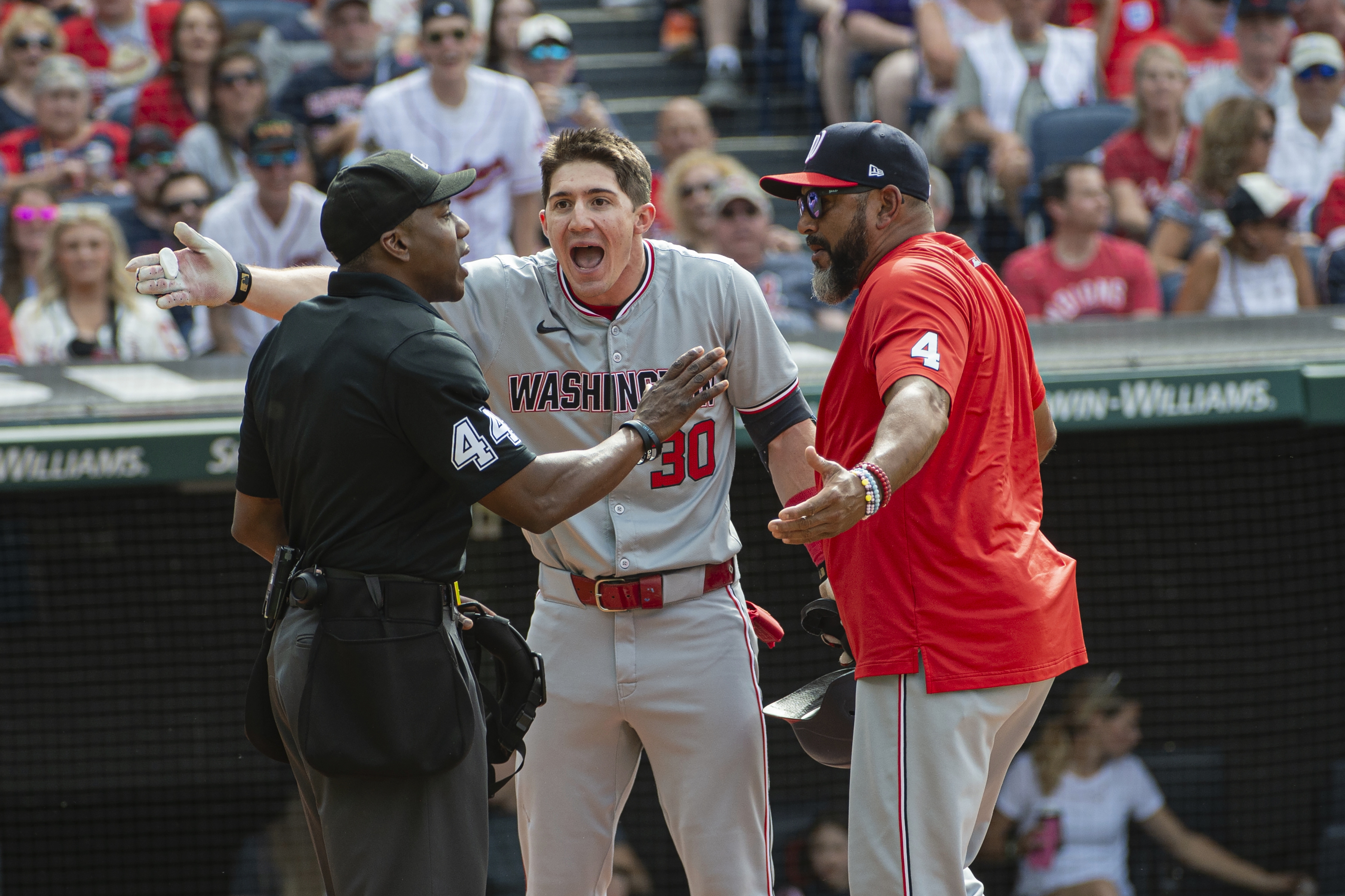 Washington Nationals' Jacob Young (30) argues a called third strike with umpire Malachi Moore, left, as Nationals manager Dave Martinez, right, joins in during the third inning of a baseball game against the Cleveland Guardians in Cleveland on June 1, 2024. (AP)