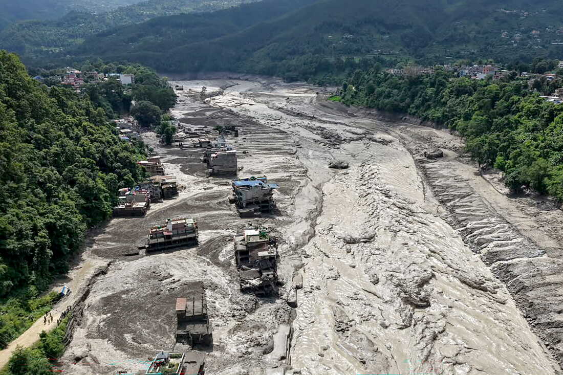 Houses lie partially submerged in muddy water along a riverside after flash floods at Trishuli Bazar in Nepal's Nuwakot district.