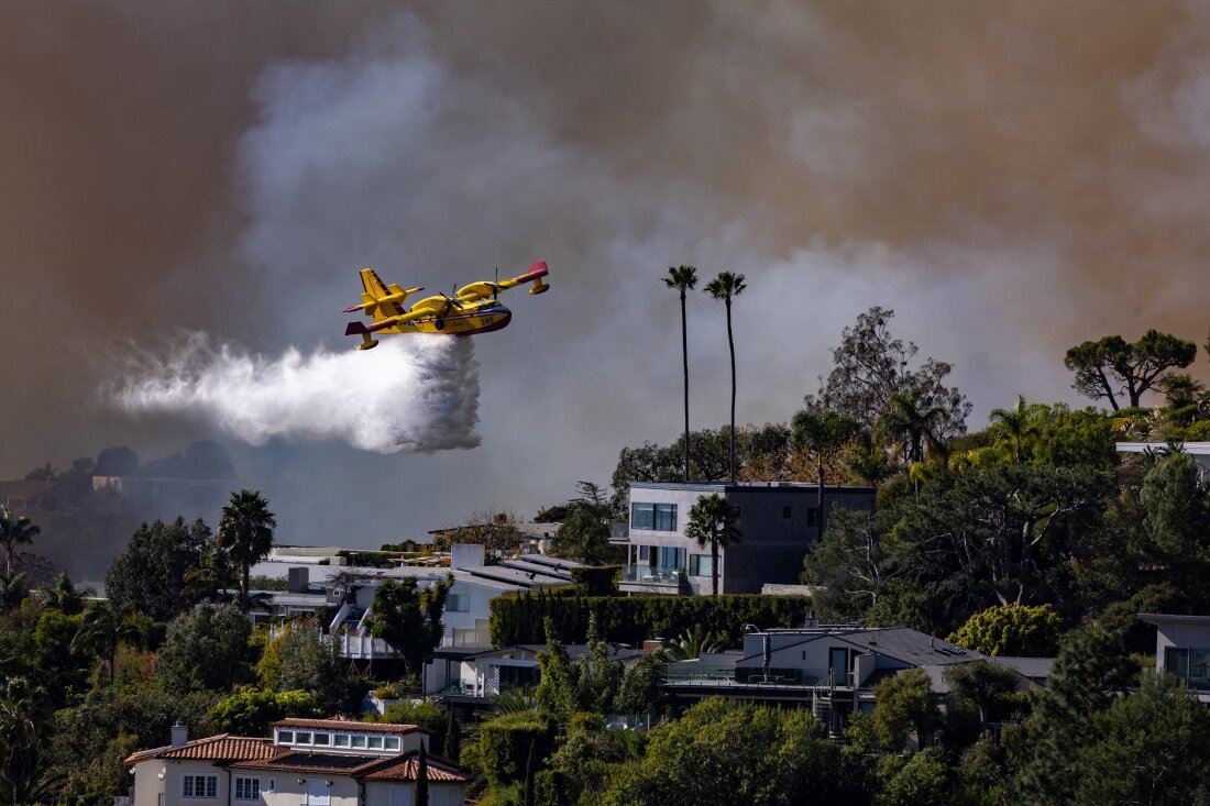 A Super Scooper plane drops water on the Palisades fire on Jan. 7 in Pacific Palisades, Calif.