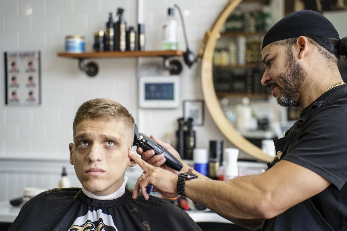 August 22, 2024, Natick, MA. 
Jason Mazzola getting his haircut by Jose Nieves at Title City.