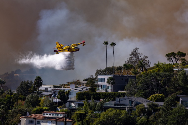 A Super Scooper plane drops water on the Palisades fire on Jan. 7 in Pacific Palisades, CA.