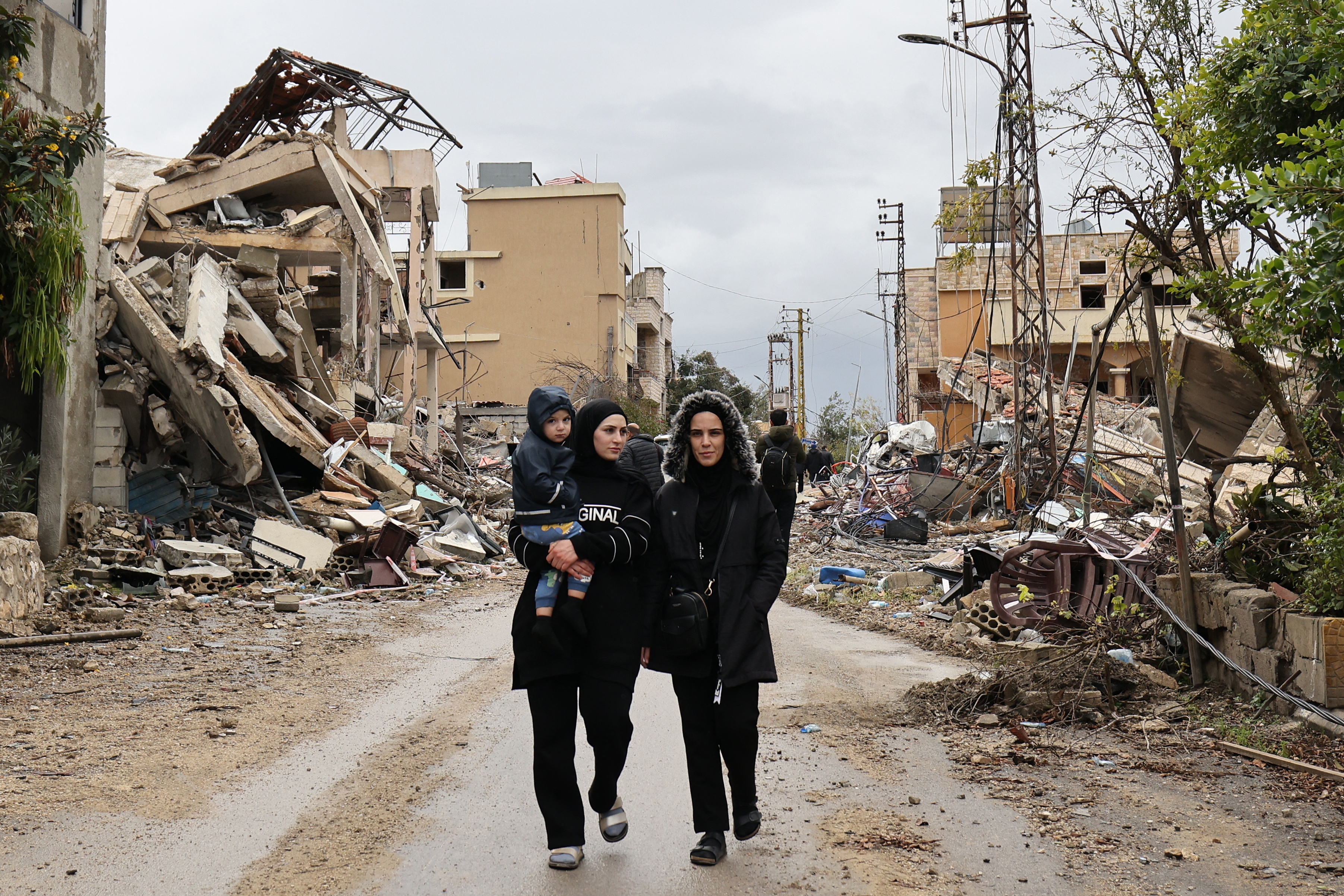 Residents walk in the southern Lebanese village of Zibqin on Wednesday, as people who had fled the war between Israel and Hezbollah returned to check on their homes after a ceasefire took effect.